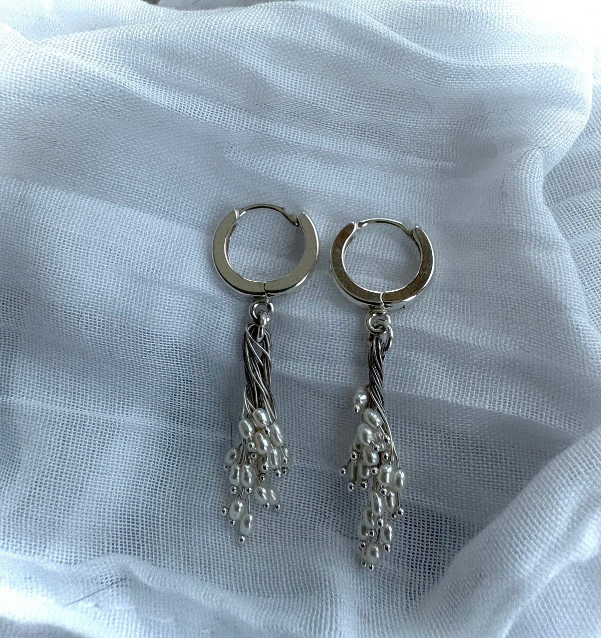 torsade. freshwater pearl earrings suspended from sterling huggie hoops