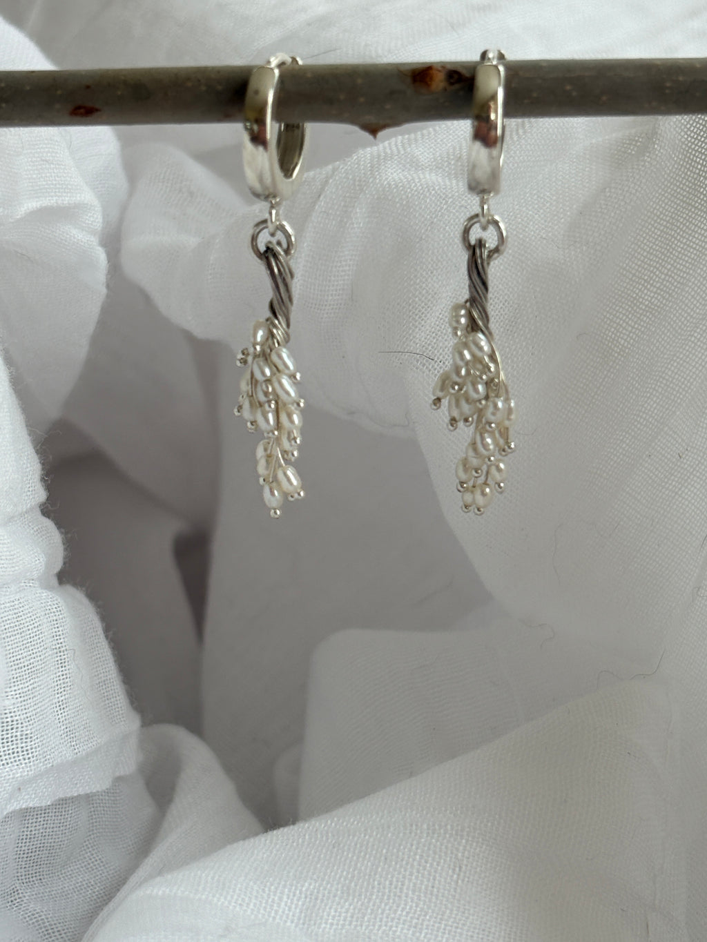 torsade. freshwater pearl earrings suspended from sterling huggie hoops